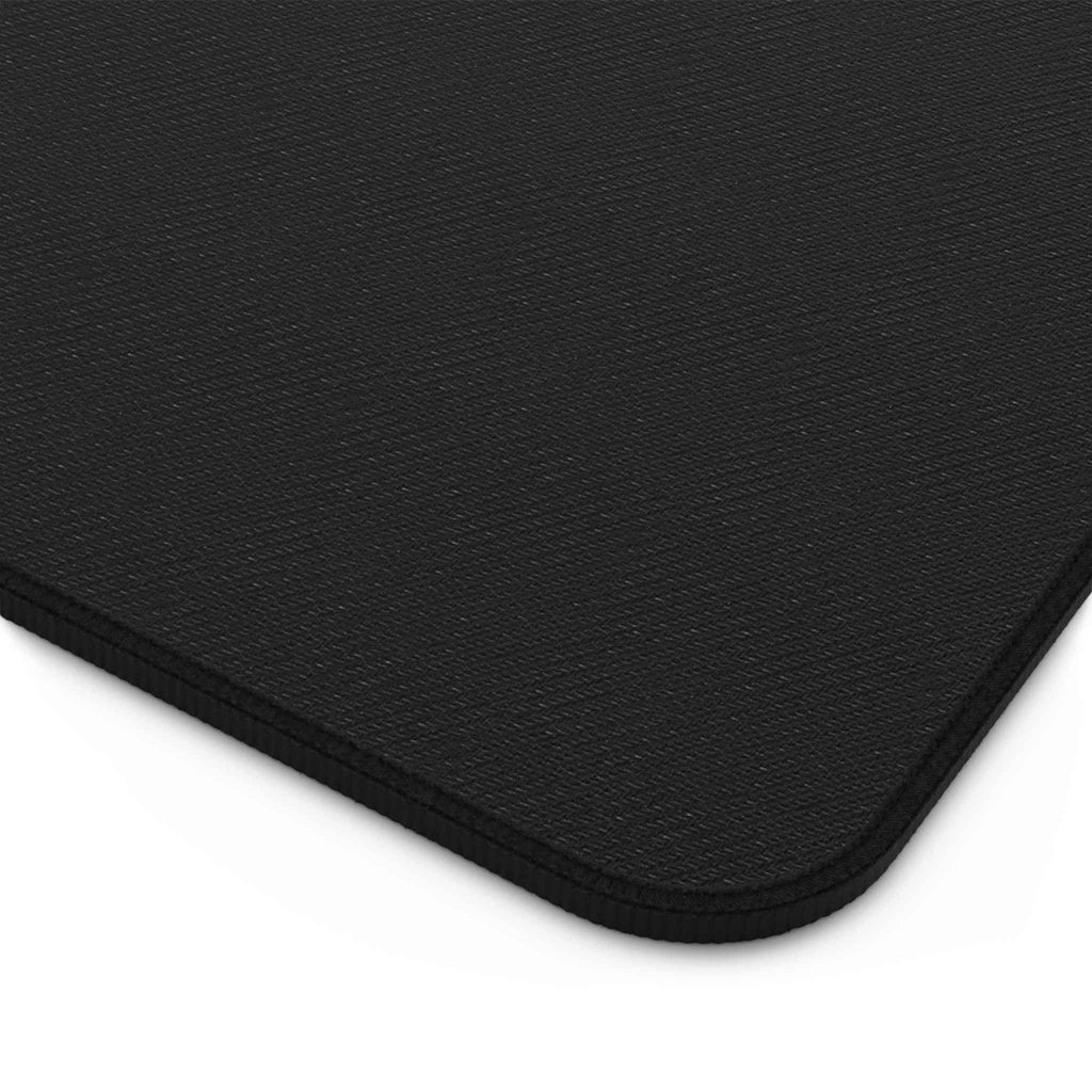 Black desk mat close-up with textured surface and stitched rounded corner edge