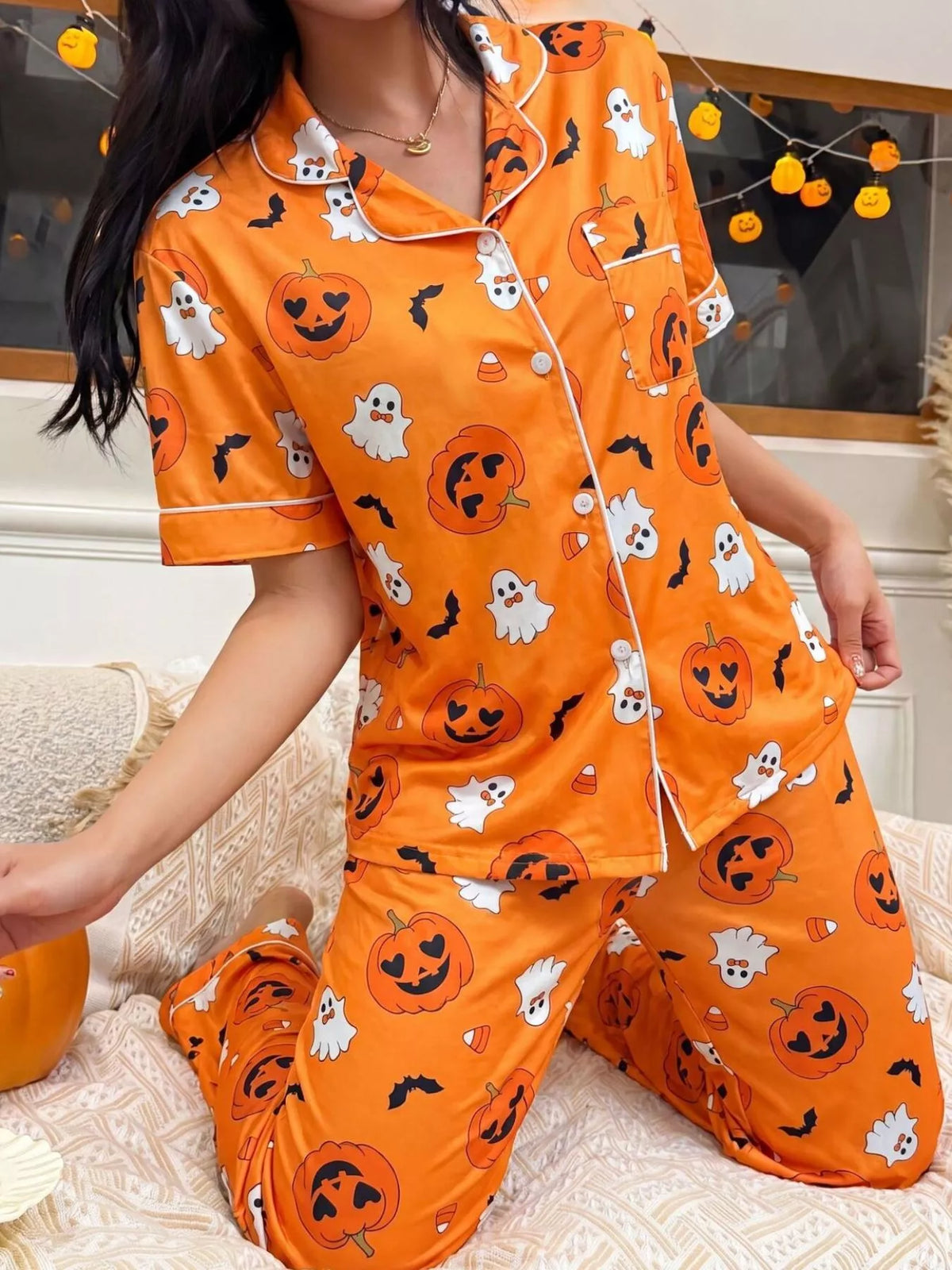 Orange pajama set with pumpkin and ghost allover print, button-front short-sleeve top and pants