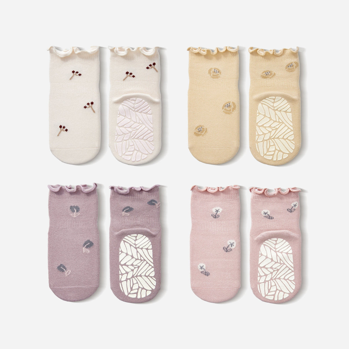 Set of 4 baby non-slip socks in cream, beige, lavender, and pink with patterned soles