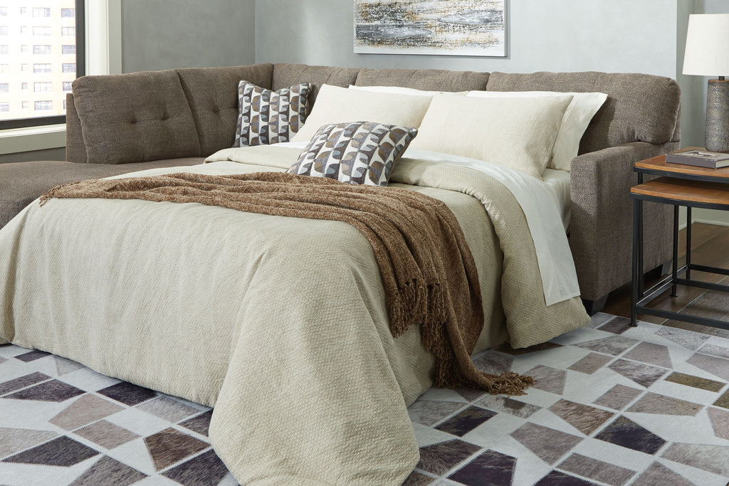 Light gray chaise sleeper sectional with tufted back, arm chaise and pull-out mattress