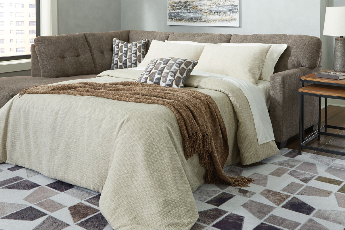 Light gray chaise sleeper sectional with tufted back, arm chaise and pull-out mattress