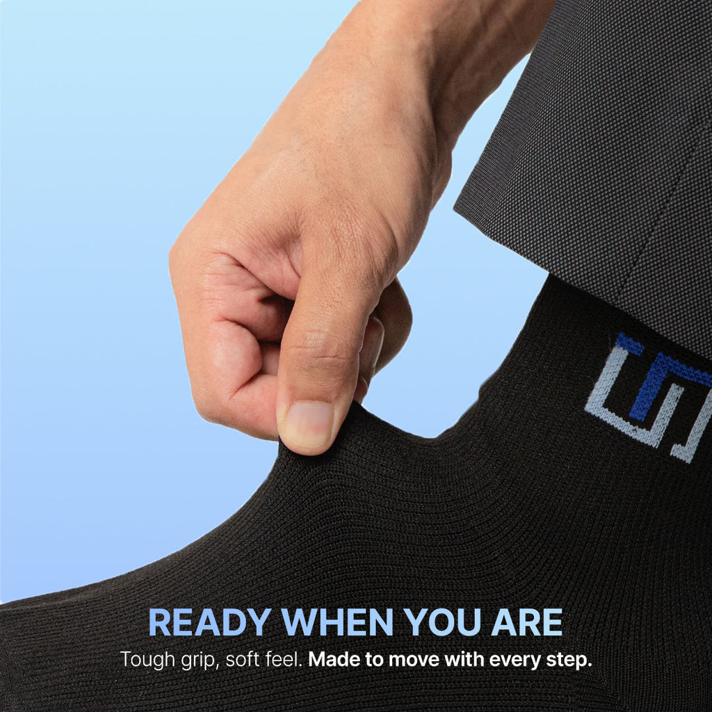 Black crew socks with blue logo patch, cuff pulled up by hand