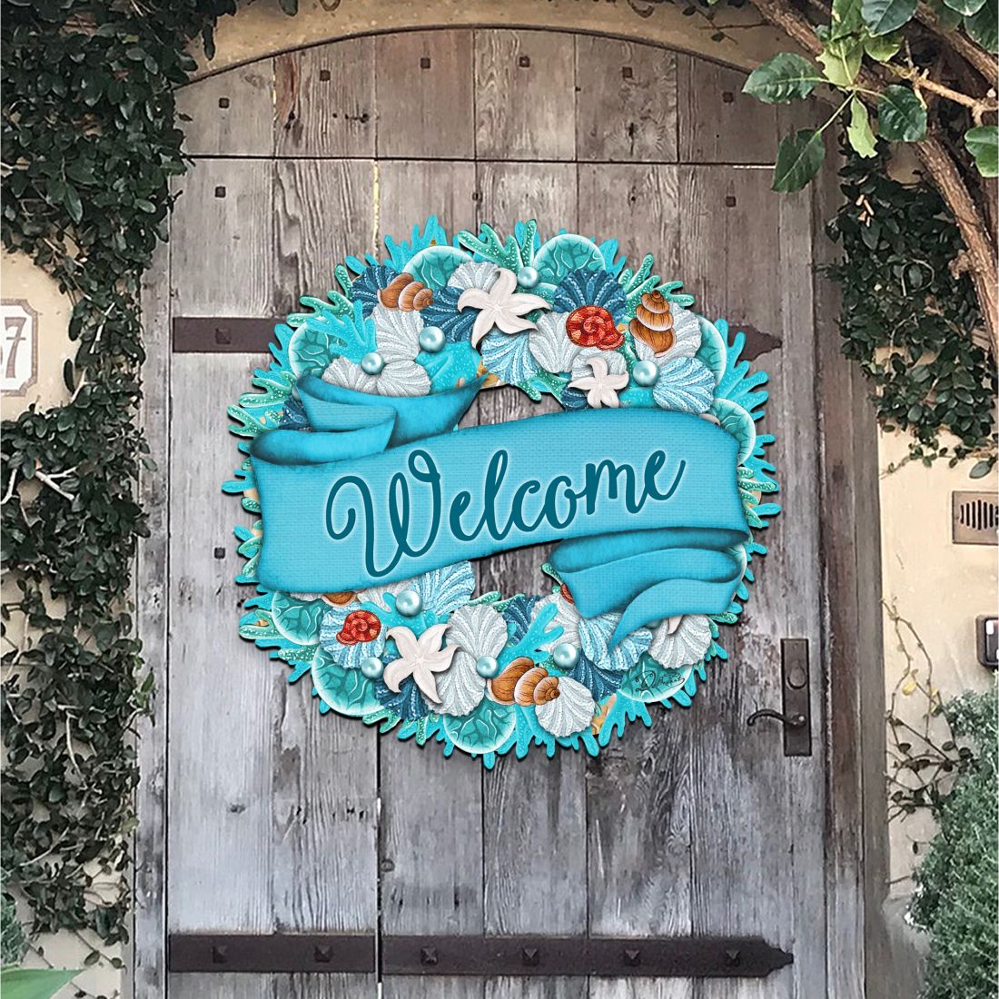 Coastal welcome wreath with blue ribbon, shells, and starfish on a front door