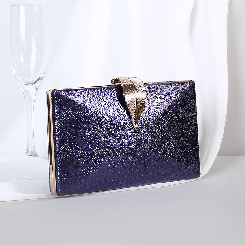 Navy textured small evening crossbody bag with gold-tone bow clasp.