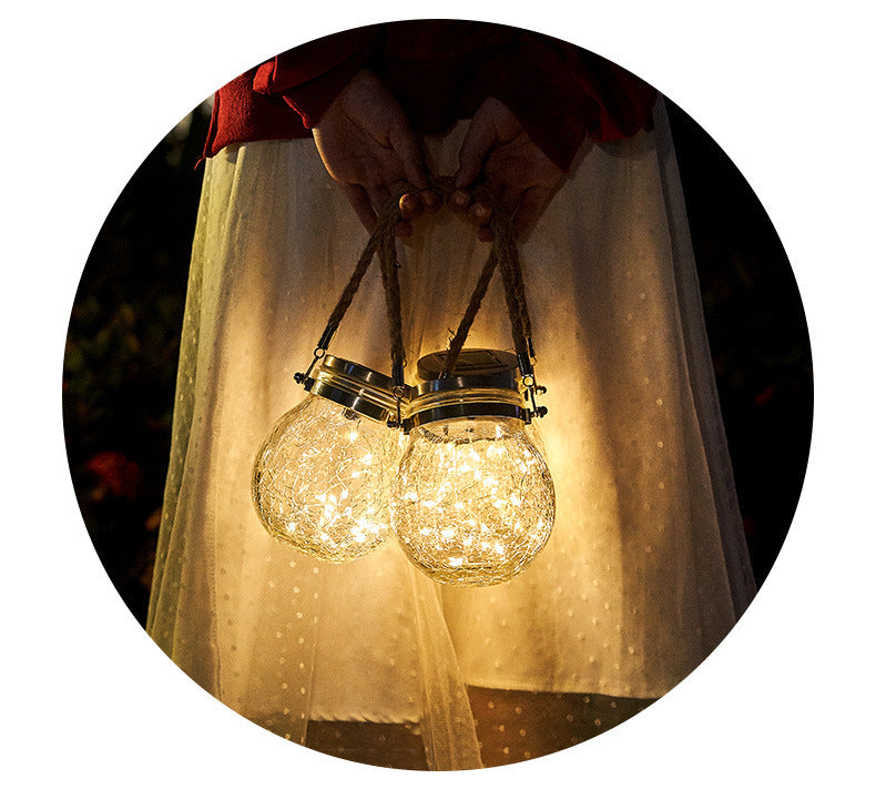 Two crackle glass jar lights with gold caps, hanging with cords