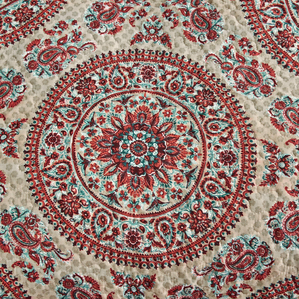 Fabric detail of centered medallion paisley in red and teal on off-white background