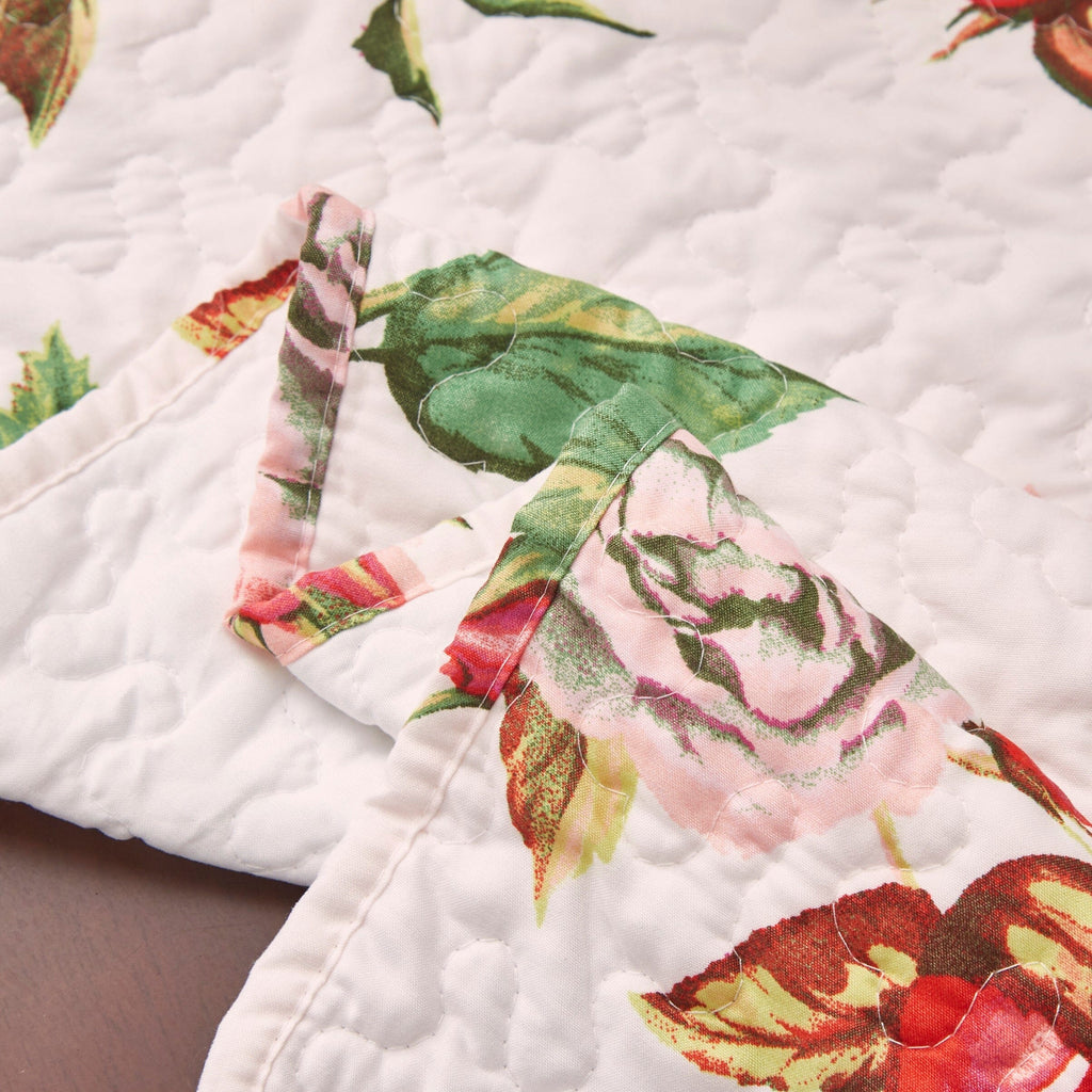 Close-up quilted dining table runner edge with rose print and stitched quilting