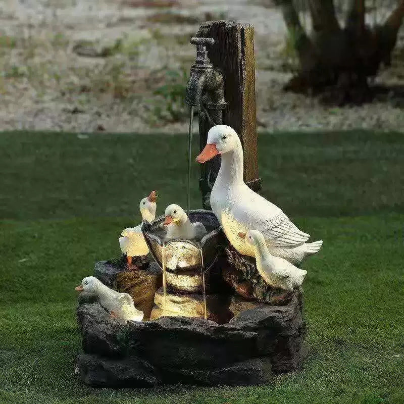 Resin garden fountain with white duck figures, squirrels, and bubbling water bowl