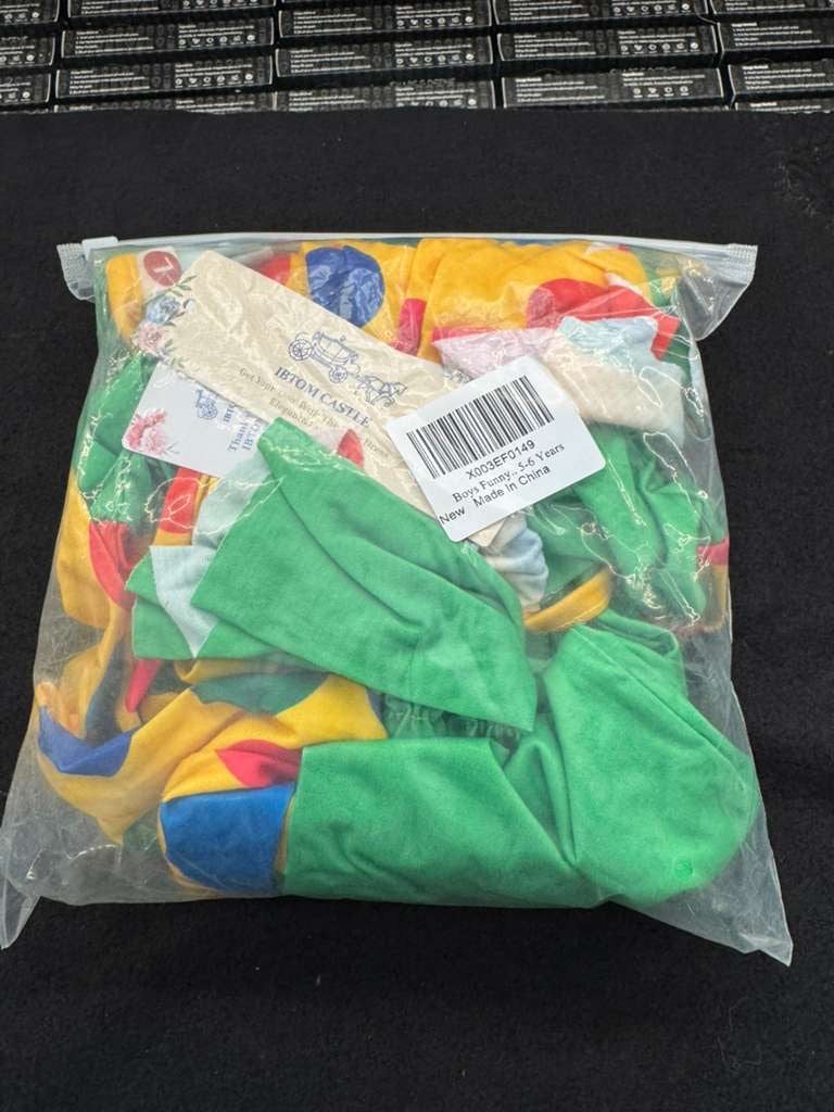 Bagged kids clown costume pieces with green pants and multicolor jester outfit fabric