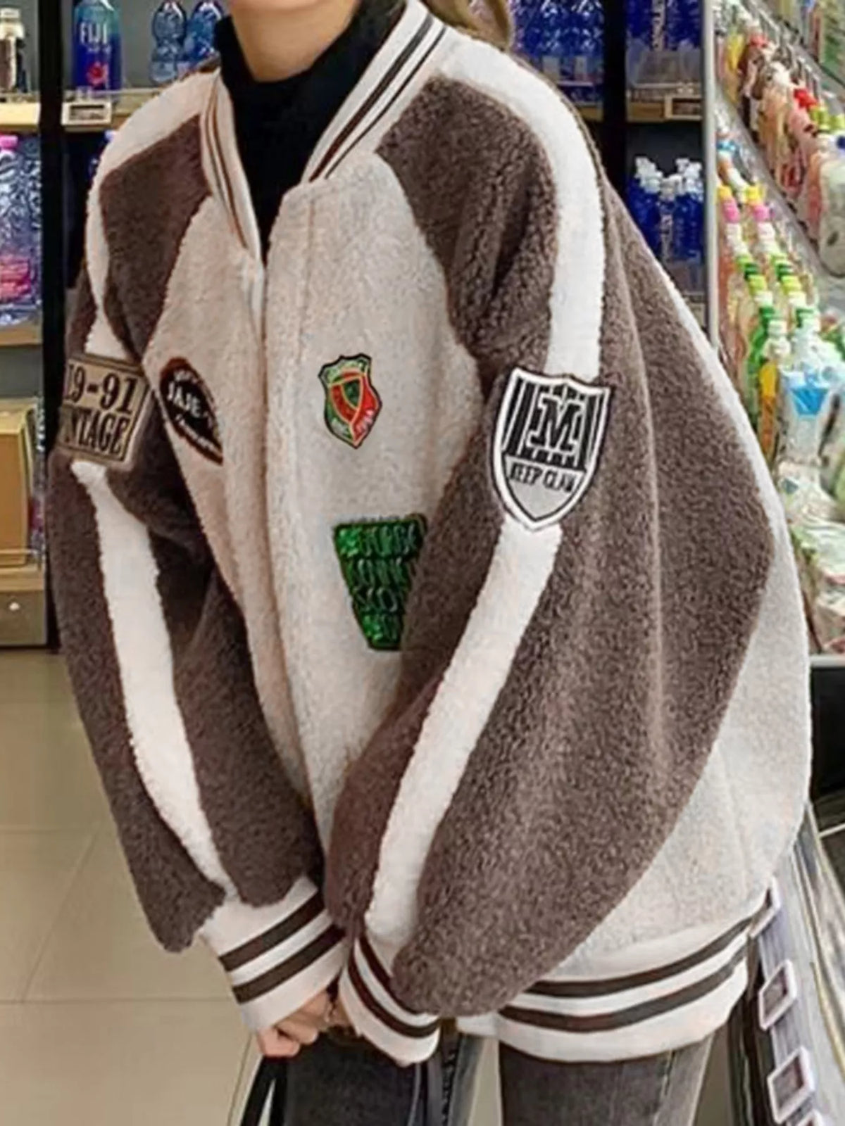 Khaki and white fleece zip-up jacket with varsity stripe cuffs and front zipper patches