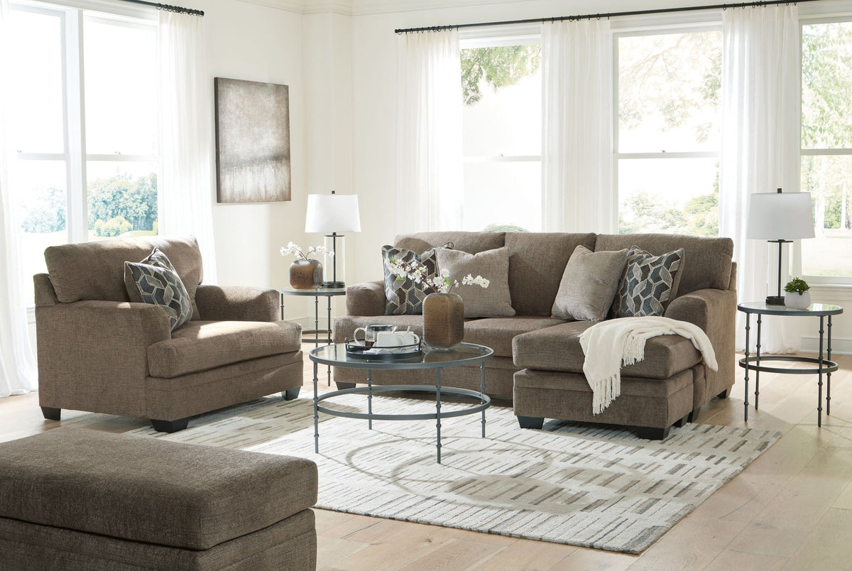 Tan fabric living room set with sofa, armchairs, ottoman, and geometric accent pillows