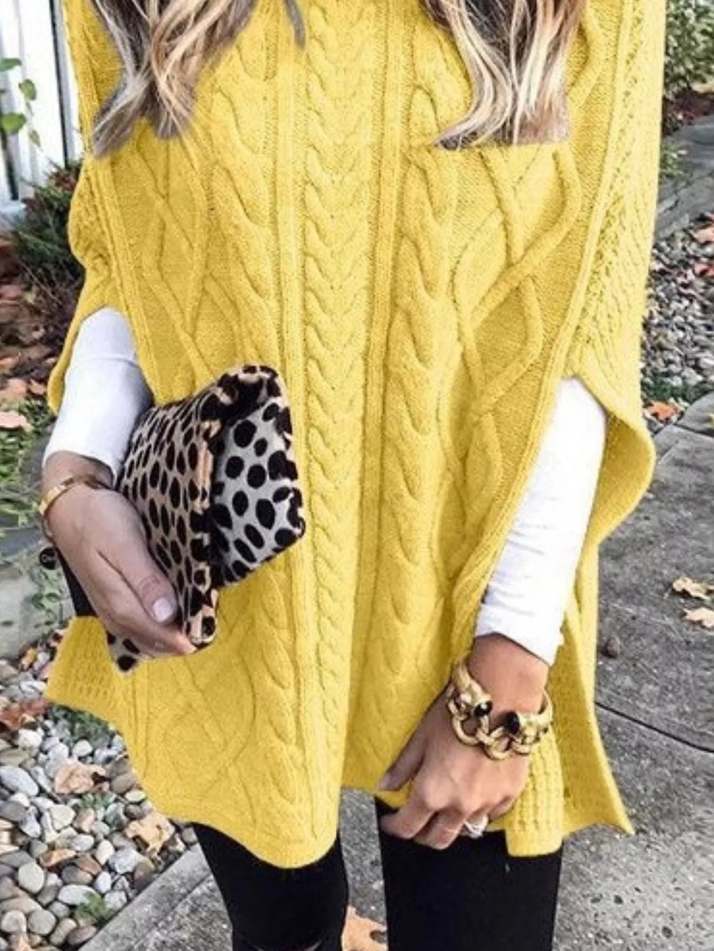 Yellow cable-knit turtleneck poncho with long drape and raised cable texture