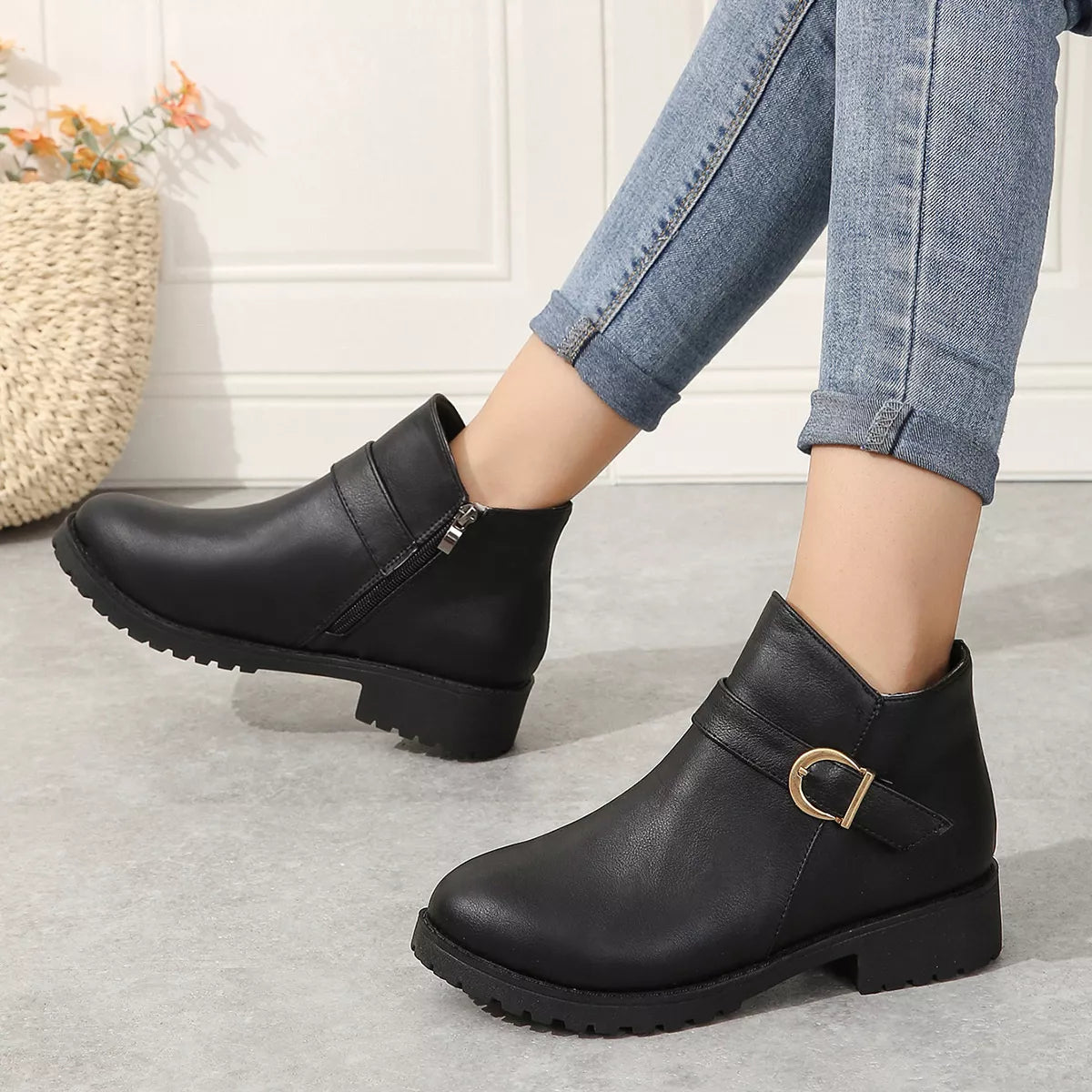Black ankle boots with gold buckle strap and side zipper, low block heel.