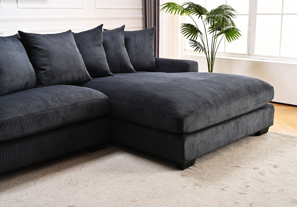 Dark gray L-shaped sectional sofa with chaise and several square throw pillows.