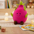 Pink dragon fruit plush toy with green leaves, smiling face and brown feet
