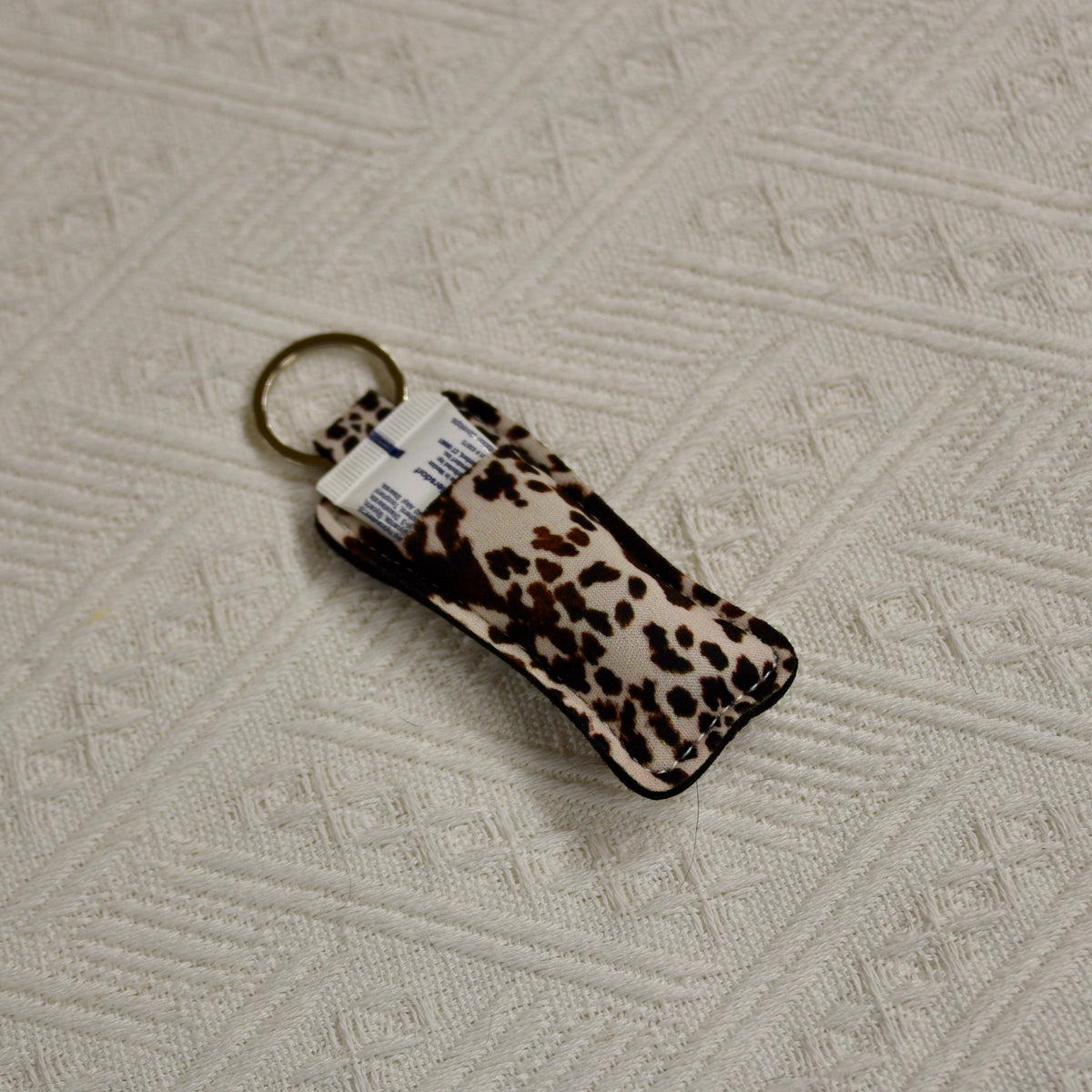 Leopard-print chapstick holder keychain with gold-tone key ring