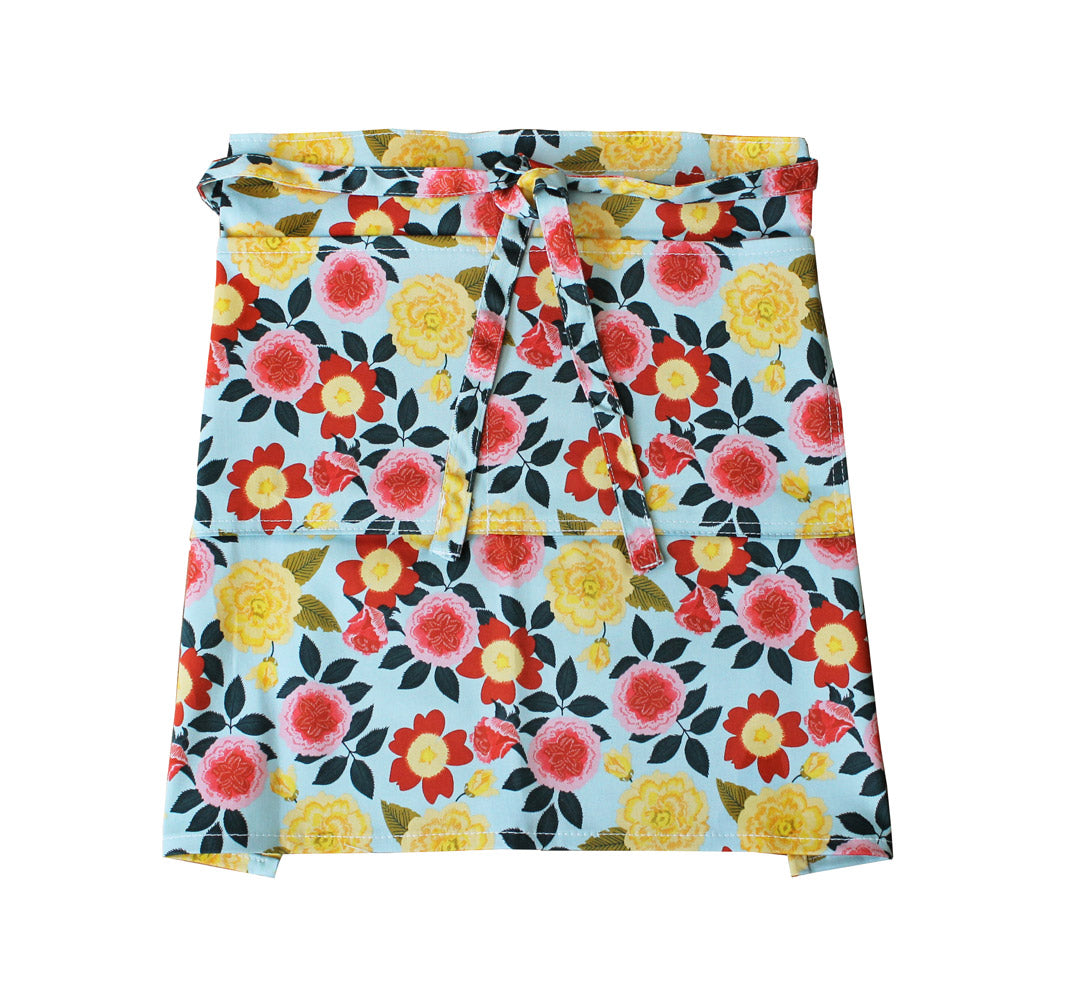 Floral half apron skirt panel with bow-tie waist, light background with multicolor blooms