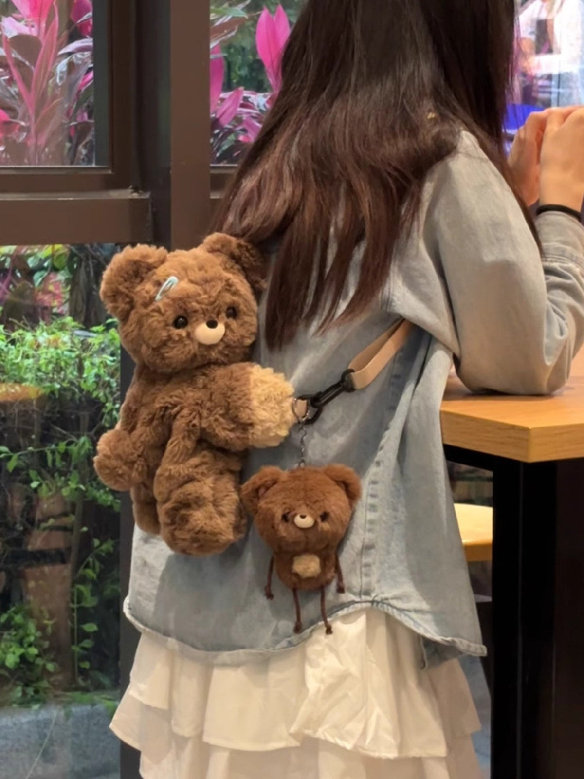Brown plush teddy bear backpack bag with a front teddy face and hanging bear charm