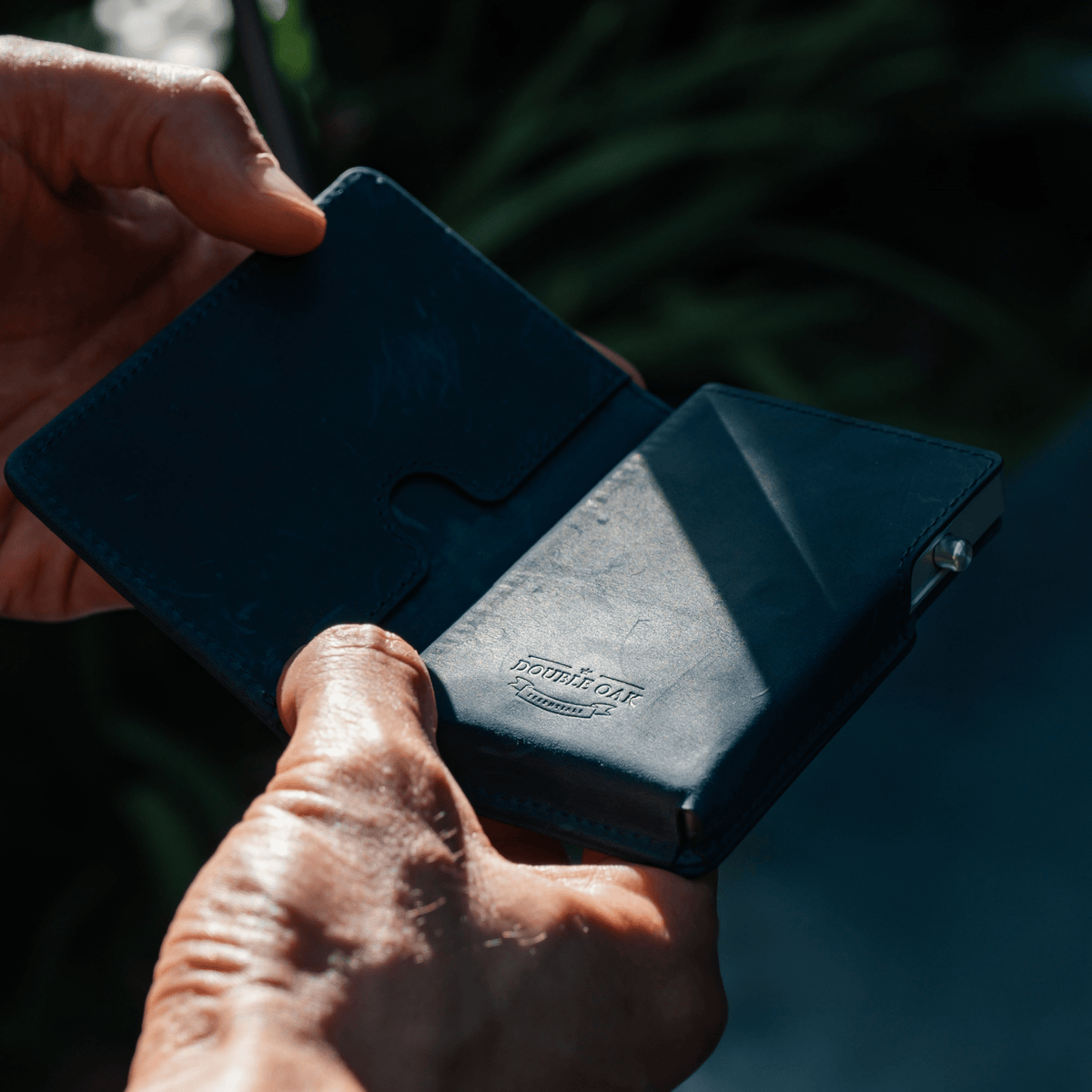 Blue leather bifold wallet open with card slots and cash compartment, close-up.