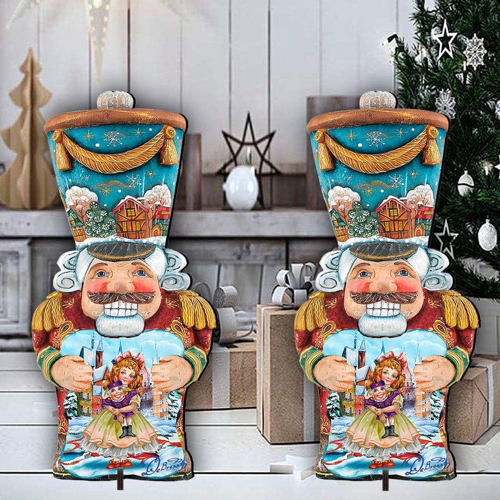 Pair of painted nutcracker holiday yard decorations with blue tops, red coats, holding dolls