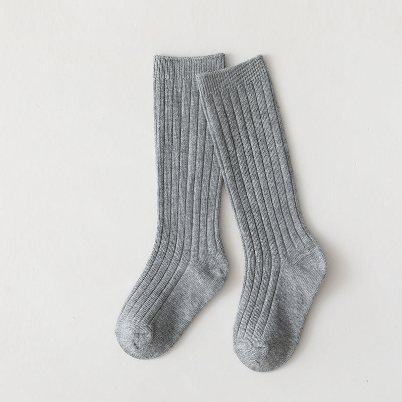 Pair of light gray mid-calf ribbed baby socks.