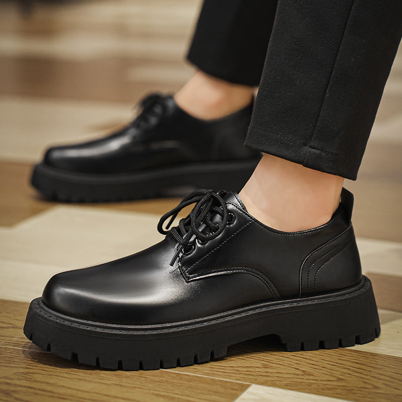 Black lace-up derby shoe with rounded toe and stitched overlays on thick sole.