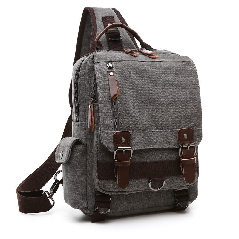 Gray canvas backpack with front flap pocket, metal buckles, and side zipper
