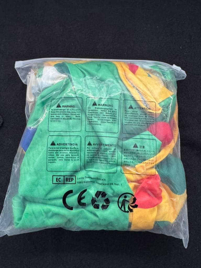 Packaged kids clown costume in green, yellow and pink fabric with jester hat