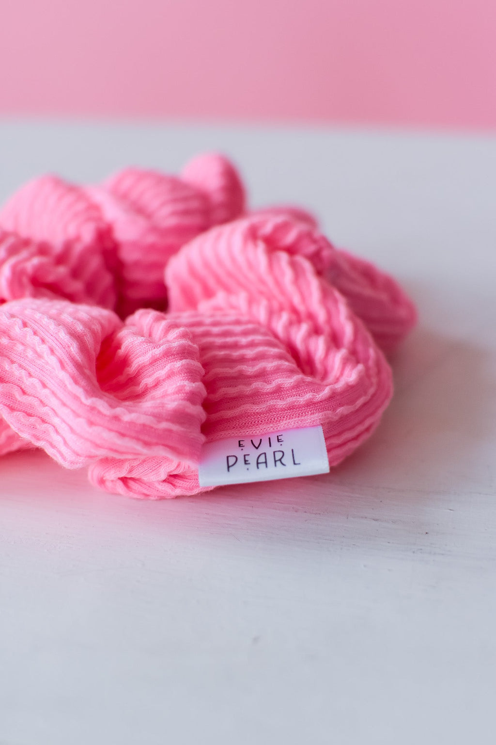 Pink ribbed regular scrunchy with brand label, bunched looped fabric