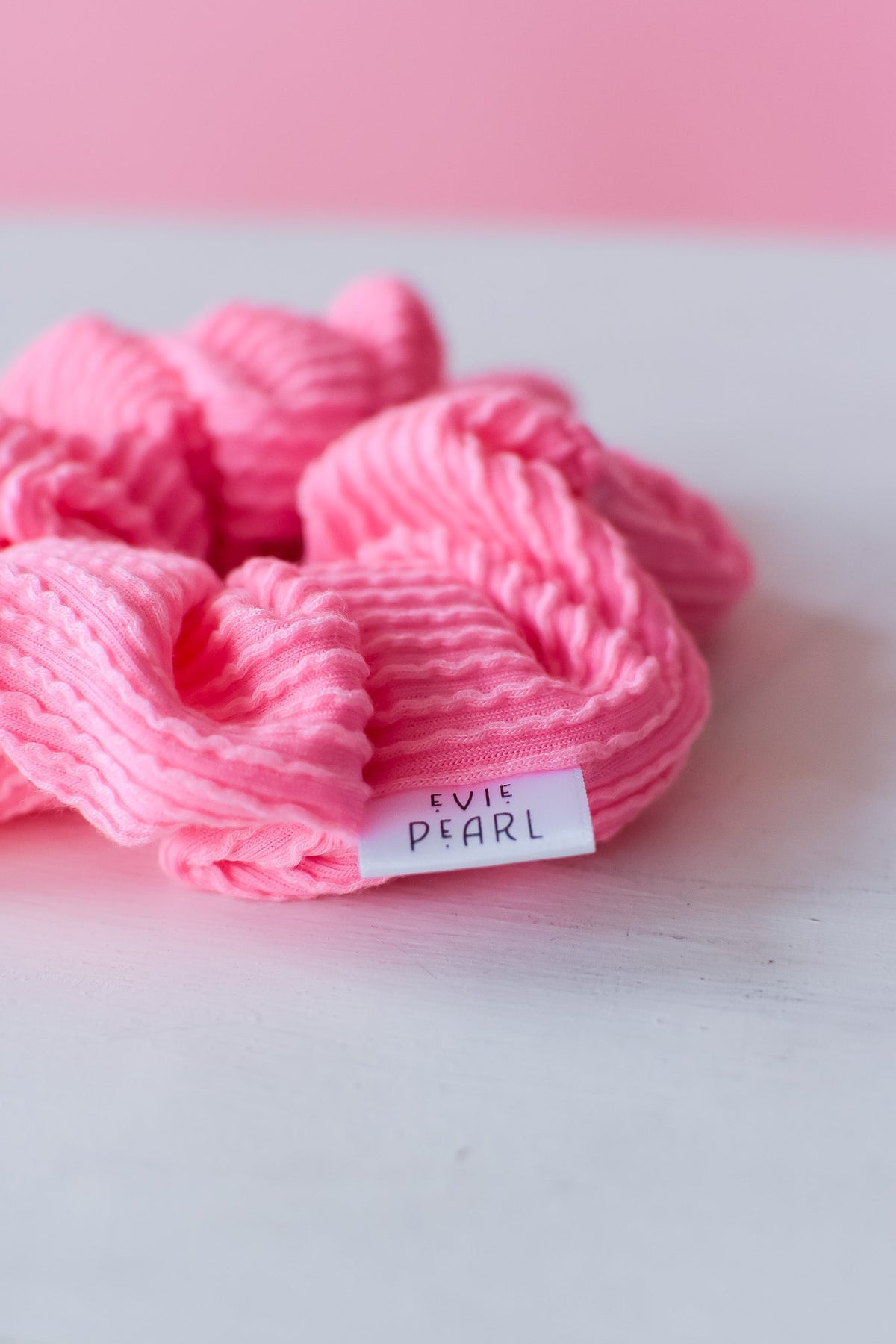 Pink ribbed regular scrunchy with brand label, bunched looped fabric