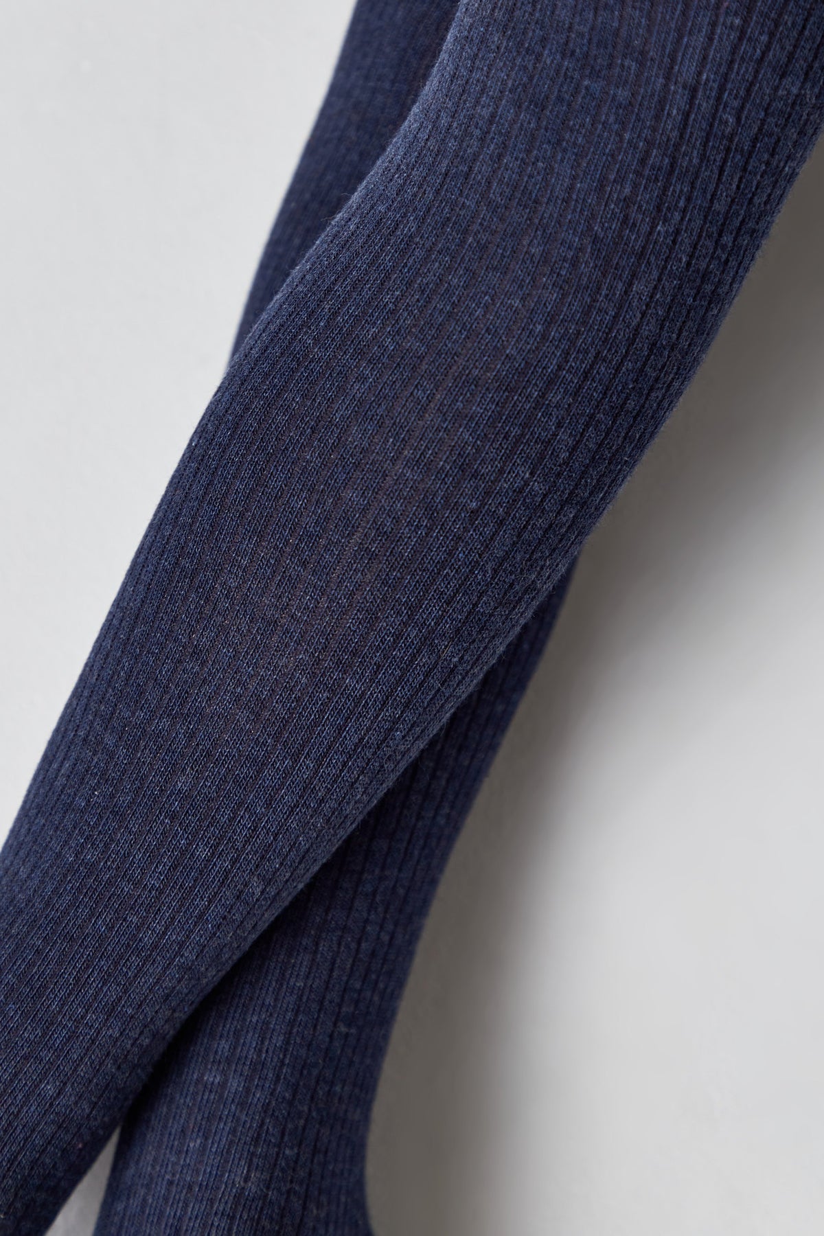 Close-up of kids cotton tights fabric, dark navy blue ribbed texture