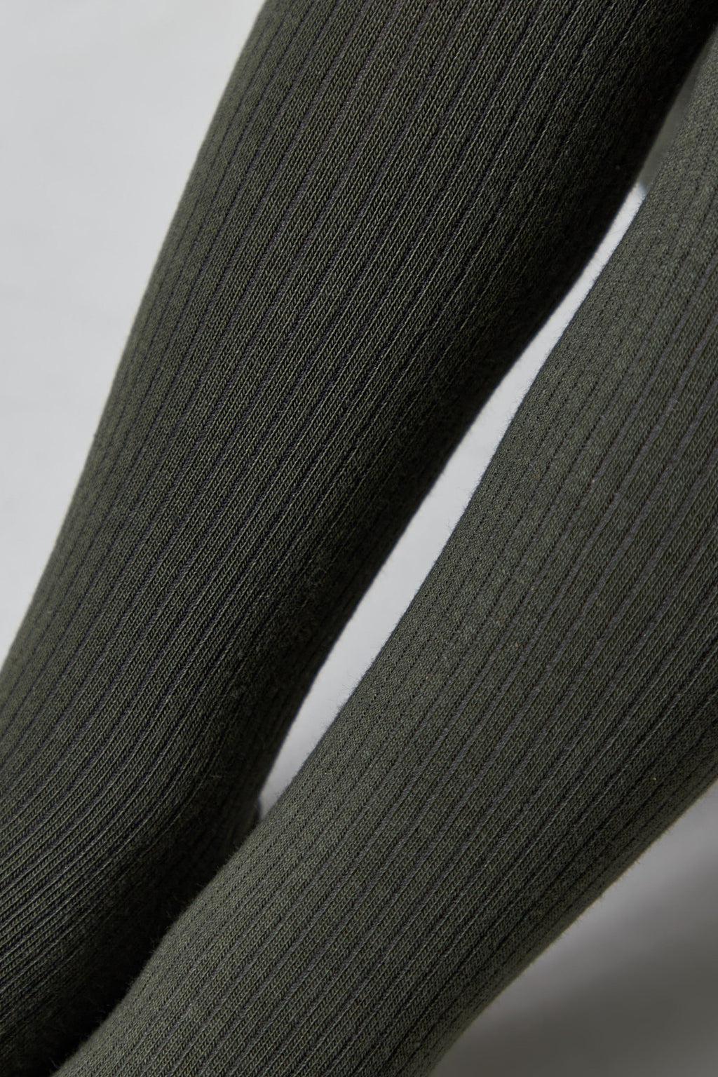 Close-up of kids cotton tights fabric, dark olive gray ribbed texture