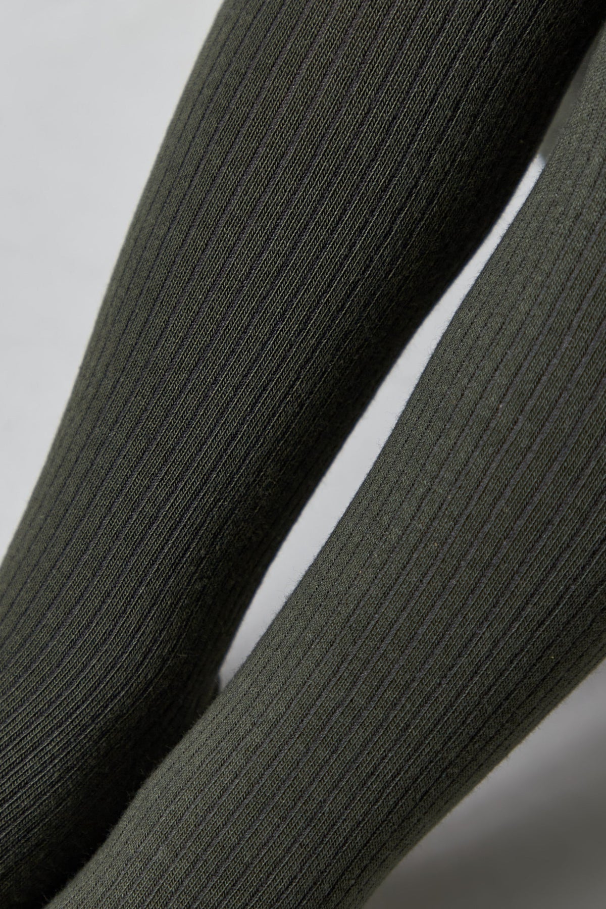 Close-up of kids cotton tights fabric, dark olive gray ribbed texture