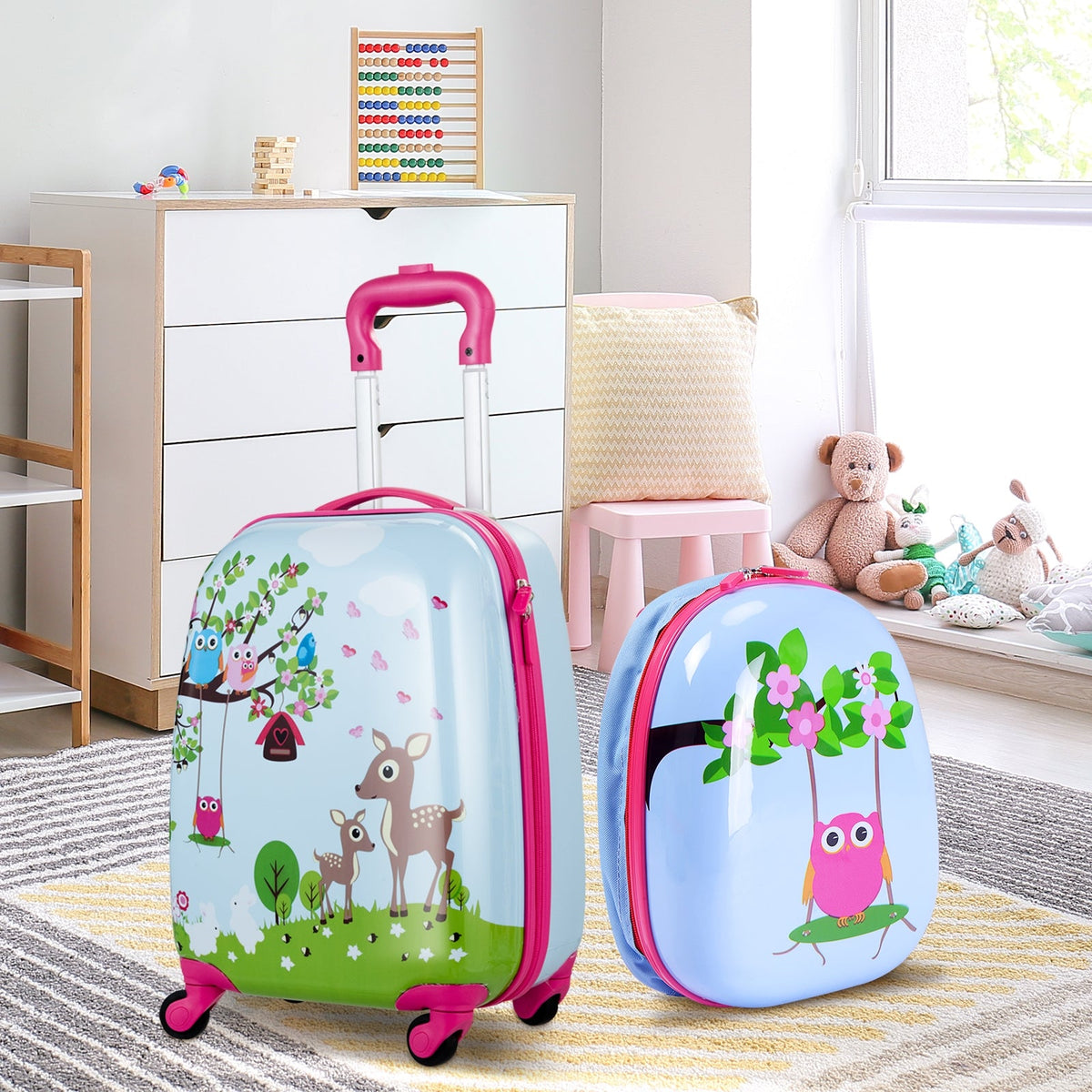 Kids luggage set on the floor indoors: blue suitcase and backpack with pink trim and animal prints