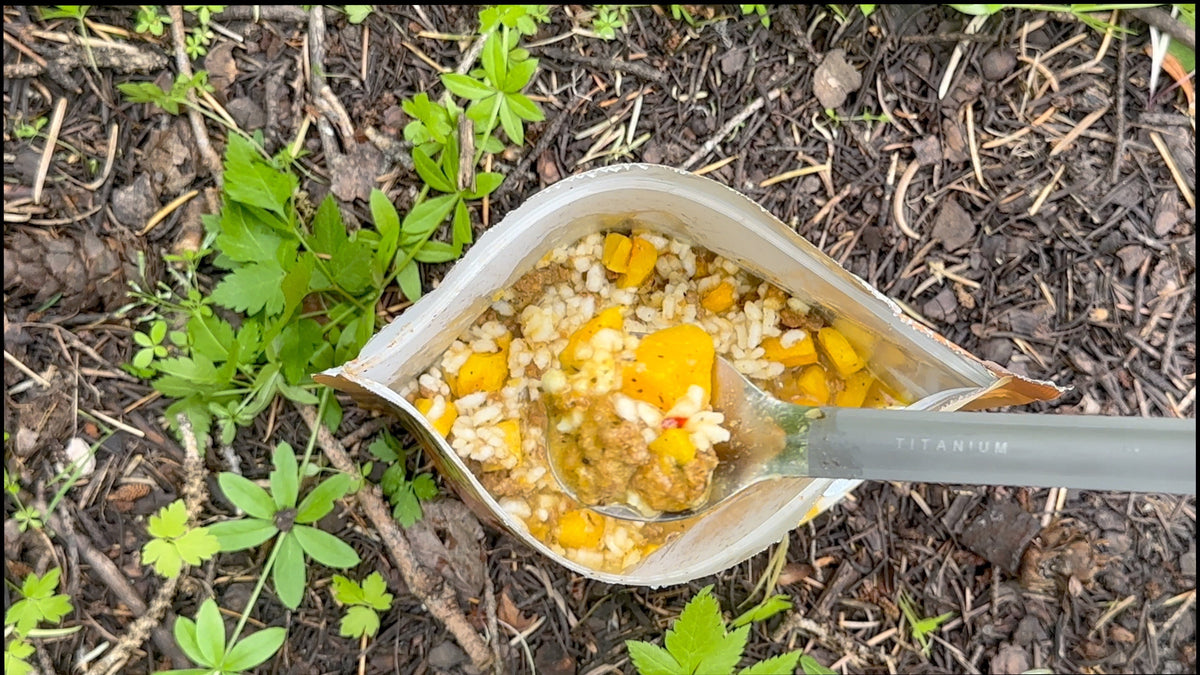 Italian sausage risotto in pouch with spoon, corn and rice visible