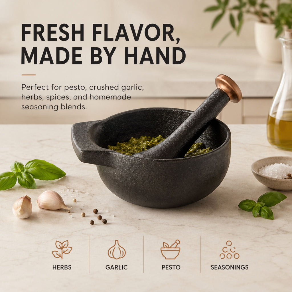 Black enameled mortar with copper pestle handle, basil and garlic on counter