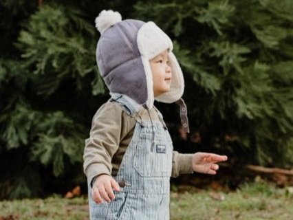 Light purple kids trapper hat with white sherpa ear flaps and top pom-pom