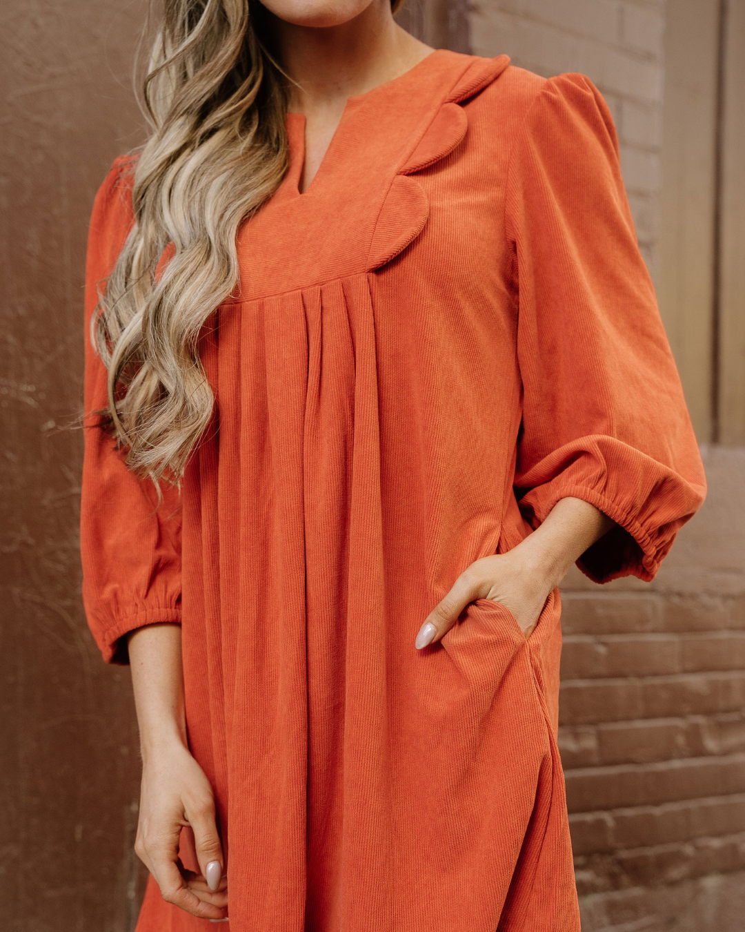 Rust corduroy mini dress detail: scalloped yoke, pleated front, gathered puff sleeves