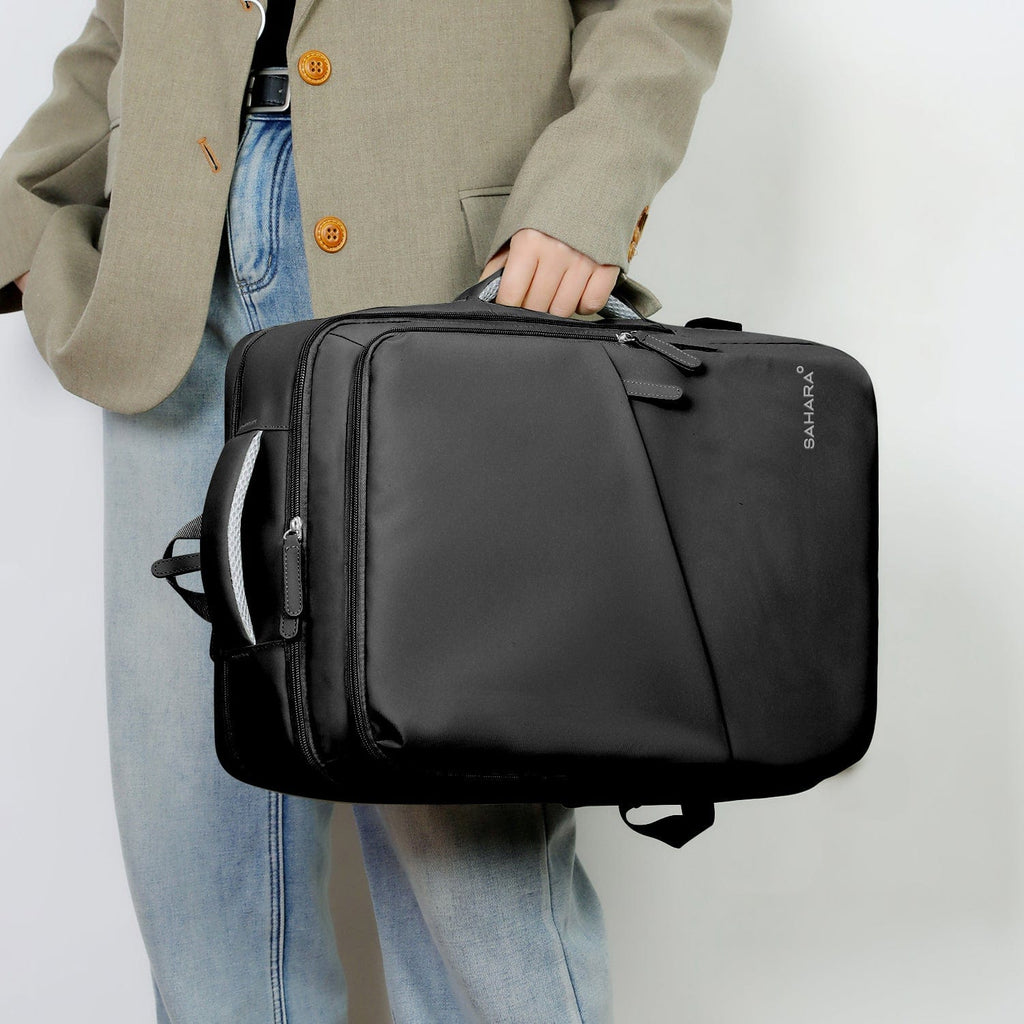 Black laptop backpack held by top handle with front zipper pocket visible.
