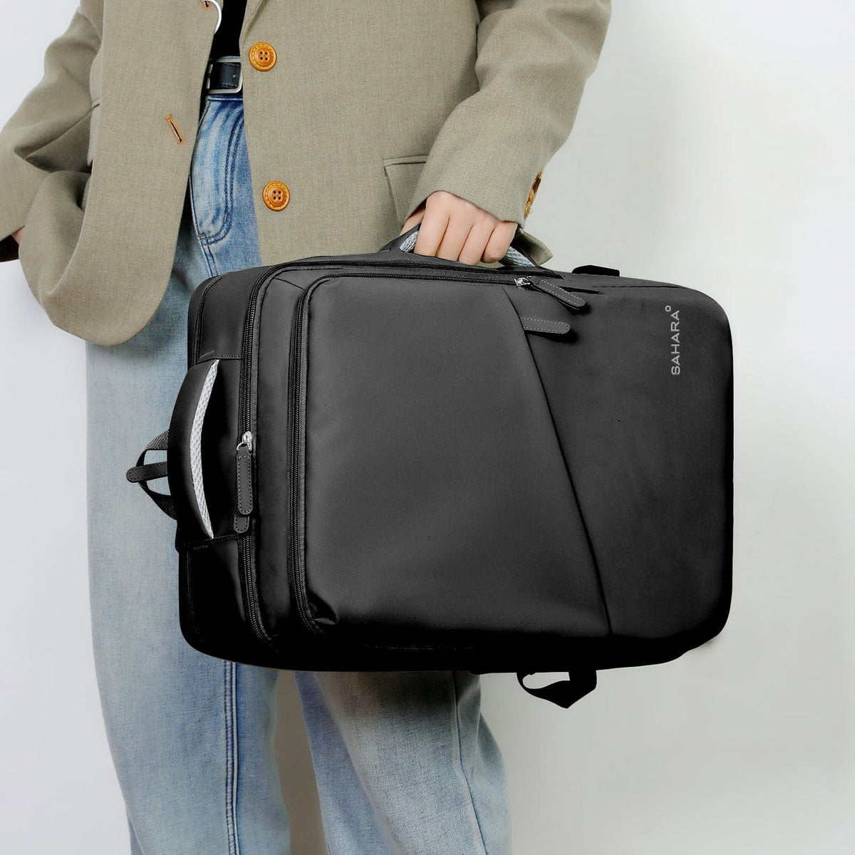 Black laptop backpack held by top handle with front zipper pocket visible.