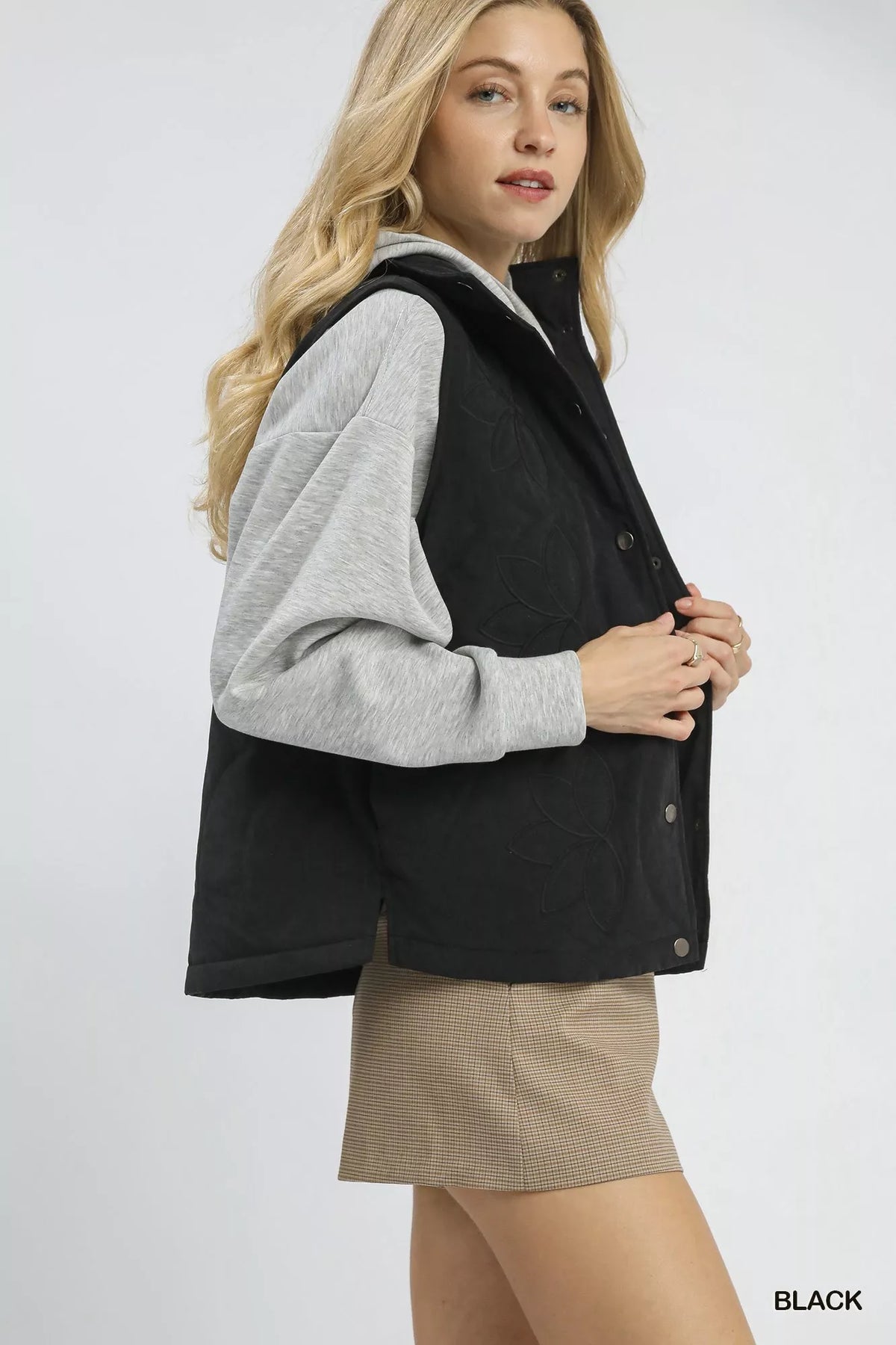 Black sleeveless quilted vest with embroidered pattern and button closure