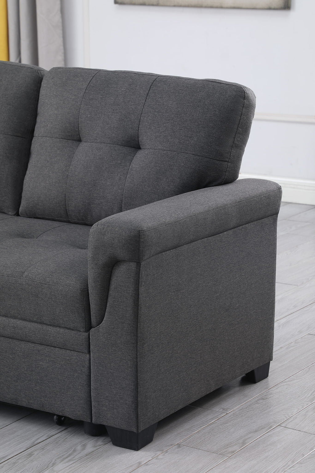 Dark gray armchair-style section of sectional sofa with tufted back and padded armrest.