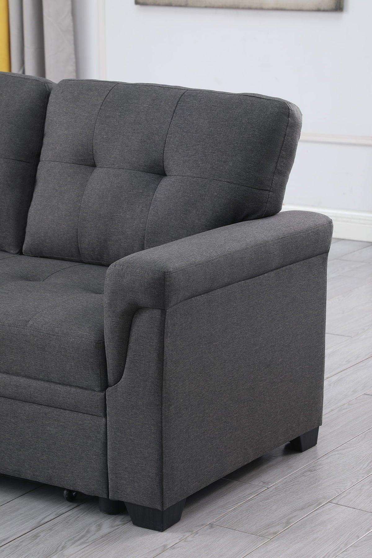Dark gray armchair-style section of sectional sofa with tufted back and padded armrest.