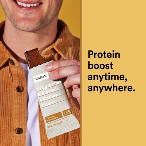 Coconut Chocolate protein bar in white RXBAR wrapper, held in hand
