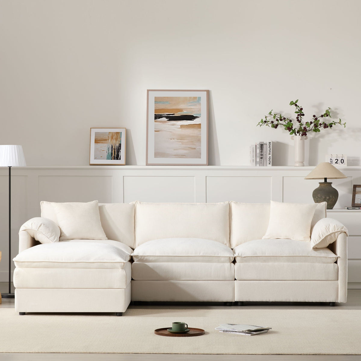Beige modular sectional sofa with left chaise, wide arms, and plush seat cushions