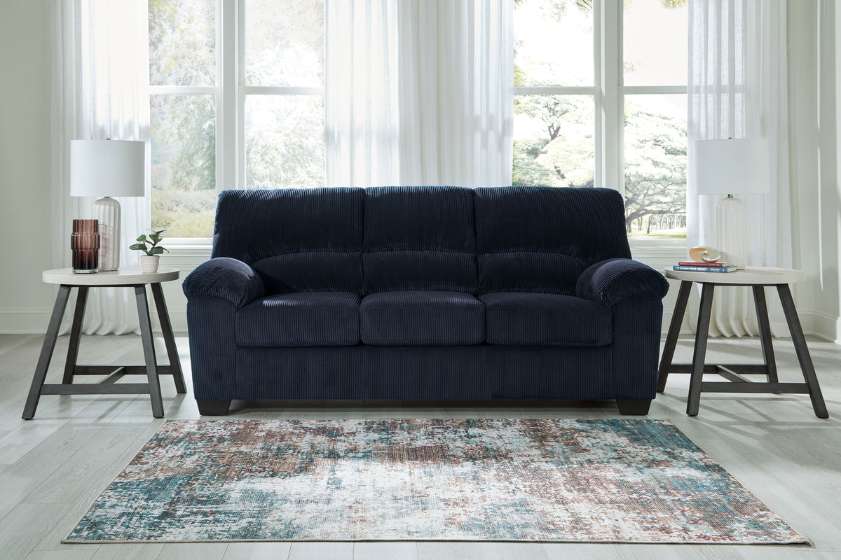 Blue sofa with tufted back cushions and rolled arms