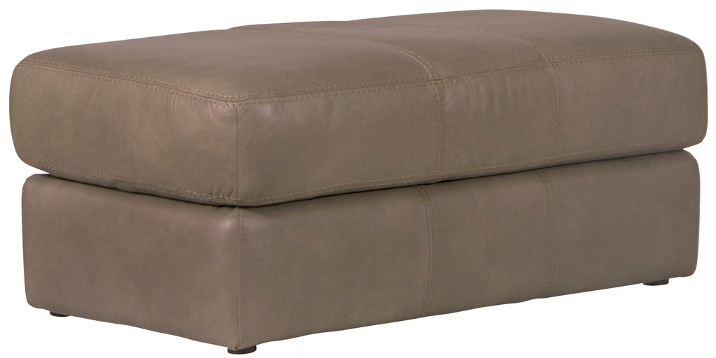 Putty leather ottoman with cushioned top and square base, stitched seams.