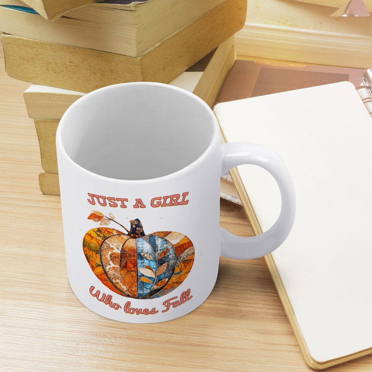 White ceramic mug with handle, pumpkin graphic, standing on a light wood surface