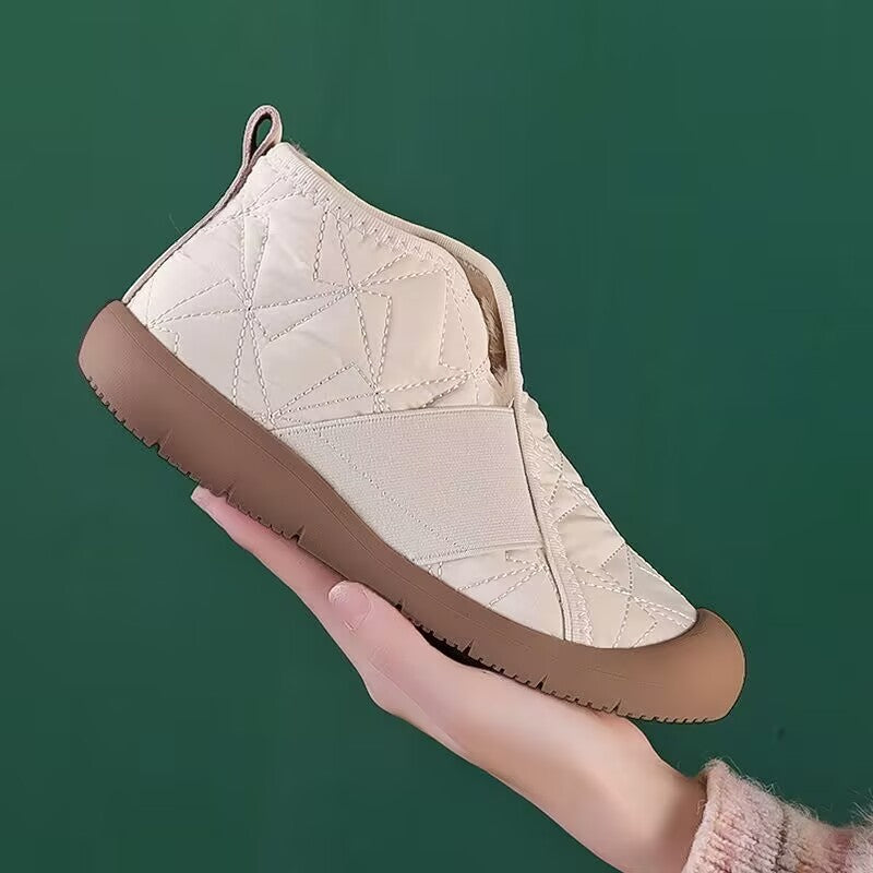 Cream quilted ankle snow boots with padded collar, fleece lining, and flat sole