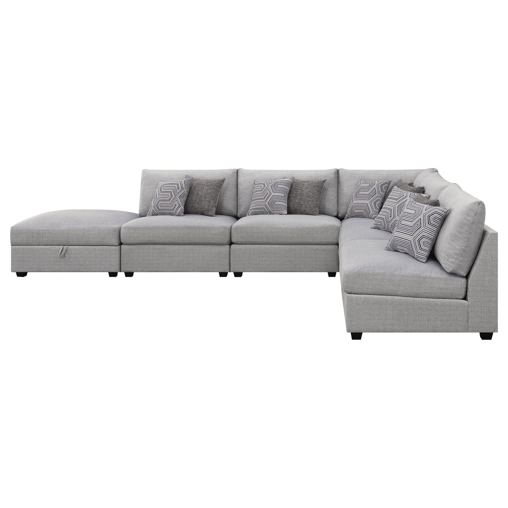 Grey modular sectional sofa with multiple seat sections and patterned accent pillows